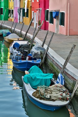 "Colors of Burano" — Limited Edition photograph available in different sizes on photographic paper or metal. Colorful buildings and boats line a canal on the island of Burano, Italy near Venice.